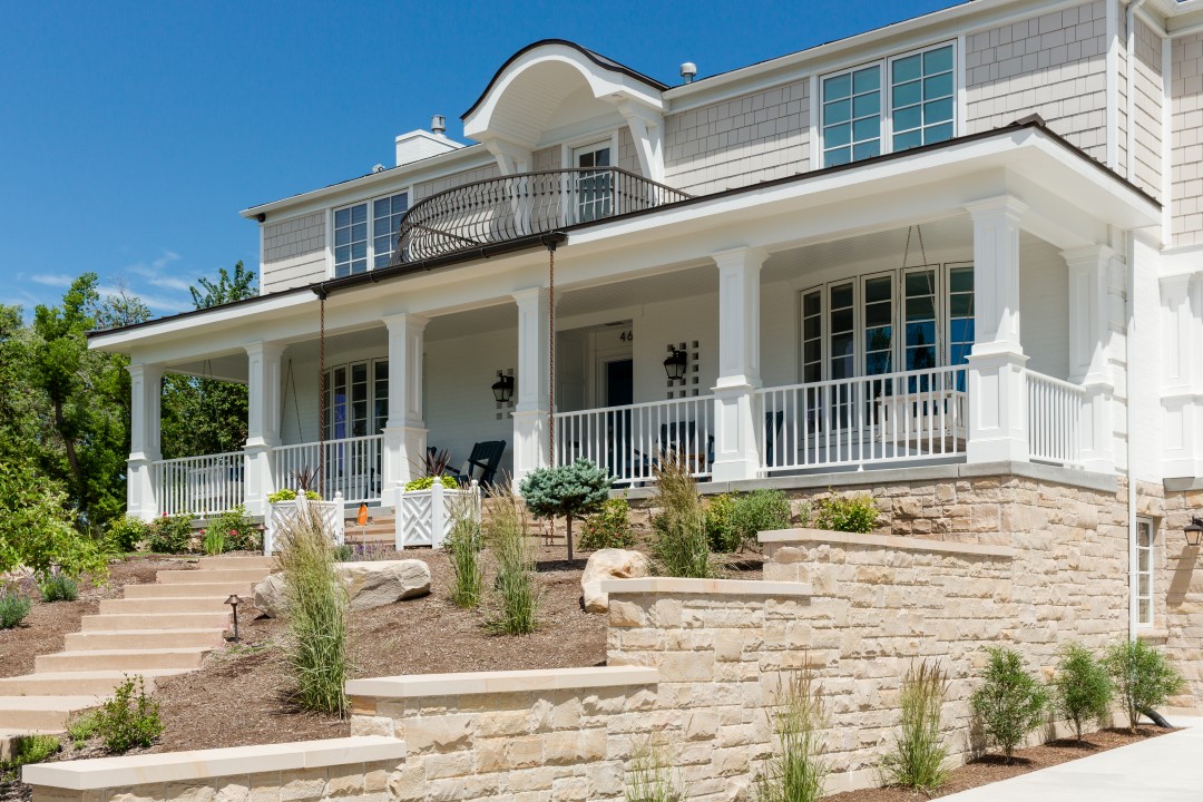 Exterior of multi-story home with a large front porch, balcony, and new landscaping.