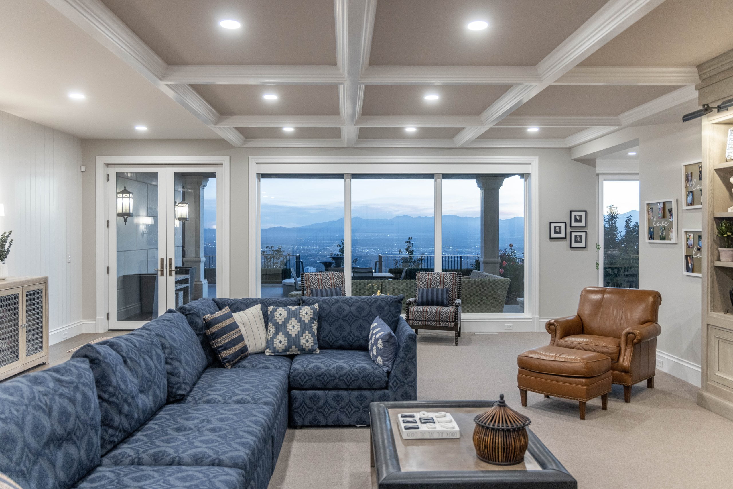 Family room after the remodel with a large couch, chairs, and windows and doors looking to the patio.