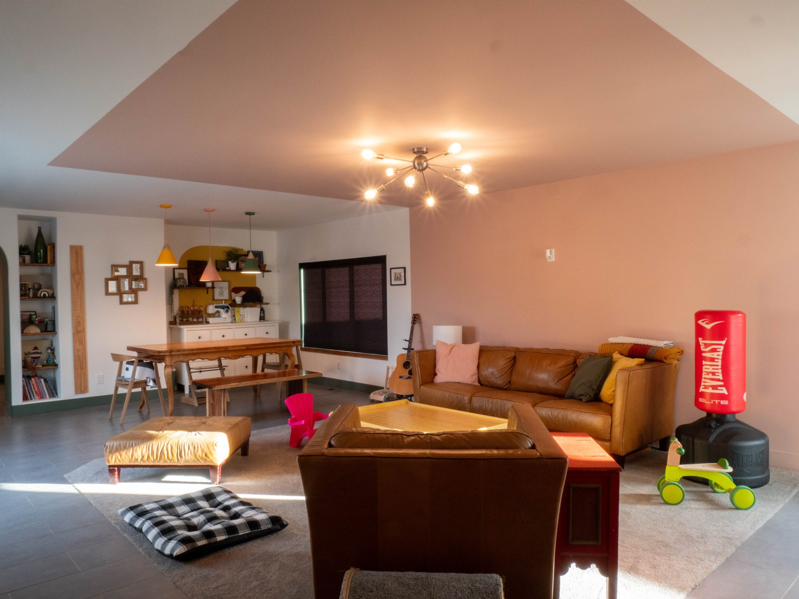 Open concept family room area with seating, toys, and a craft table.
