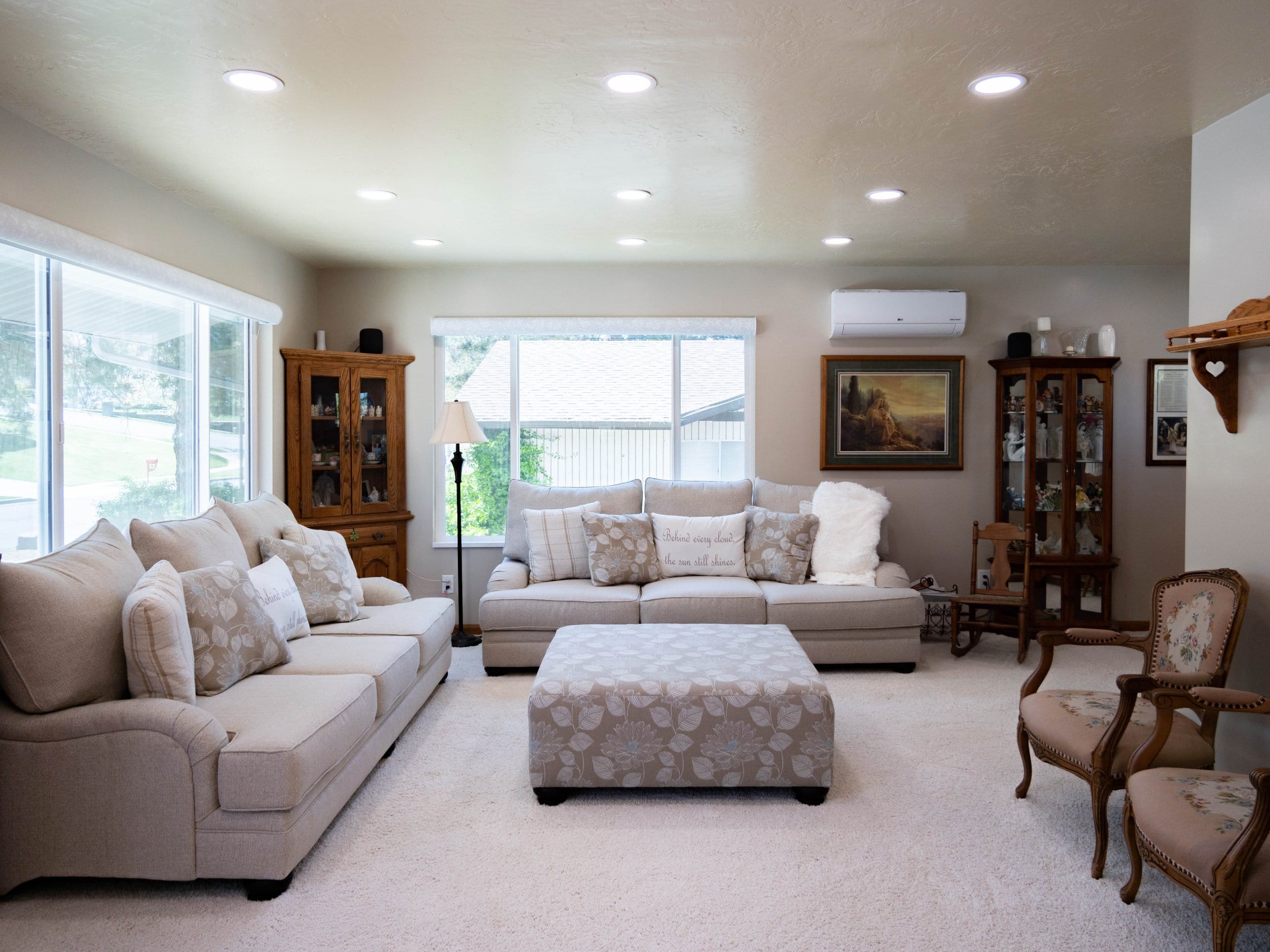 Family room remodel with the two couches under the windows, bookcases, and chairs around the ottoman in the center.