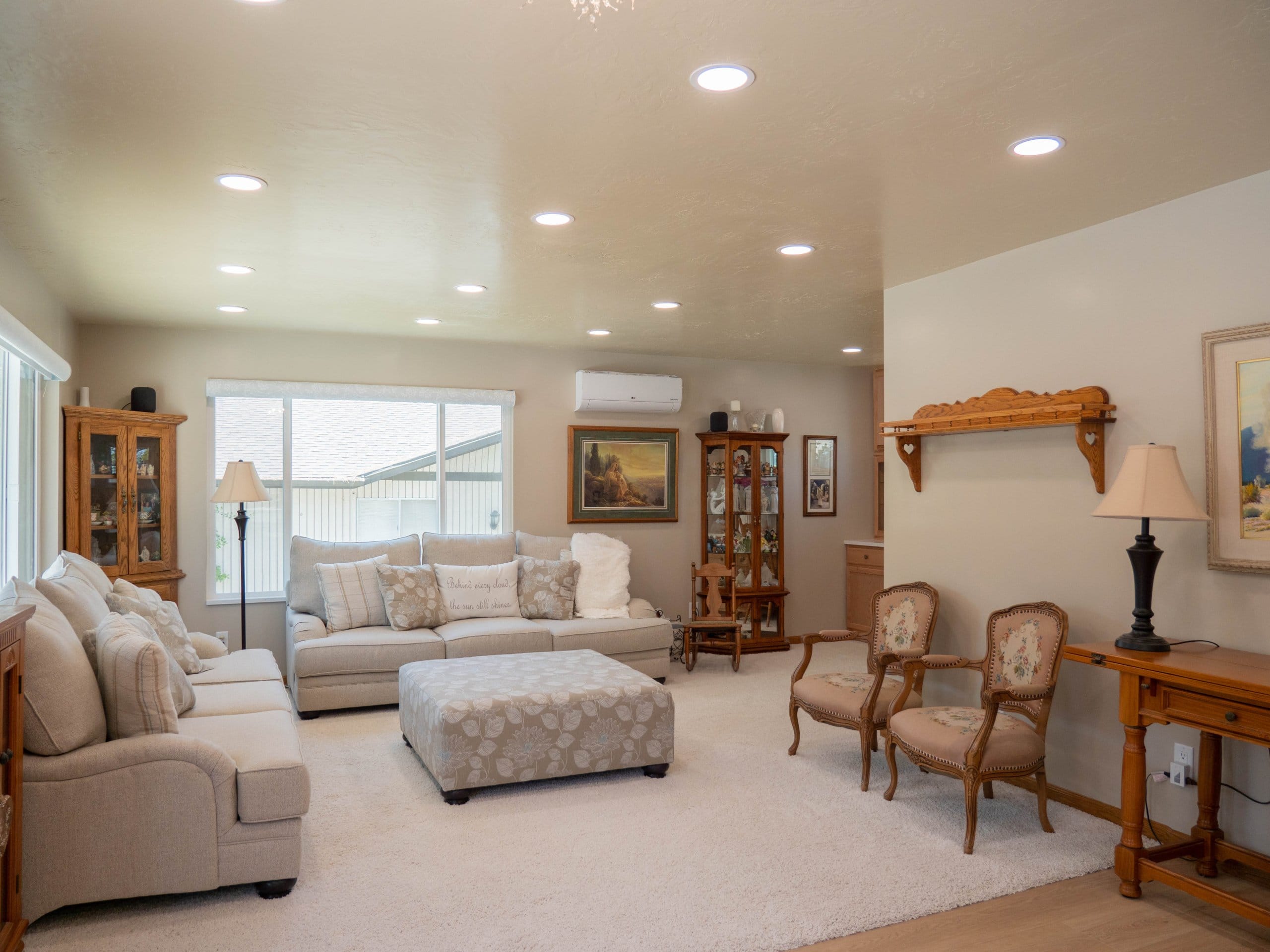 Family room remodel with the two couches under the windows, bookcases, and chairs around the ottoman in the center.