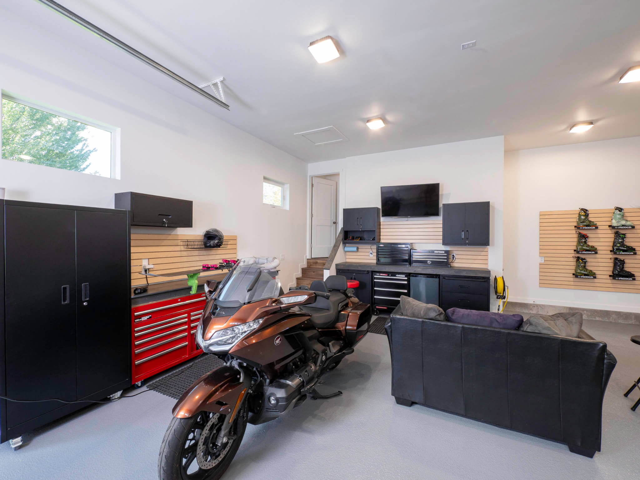 Garage workshop with a motorcycle and couch in the middle.