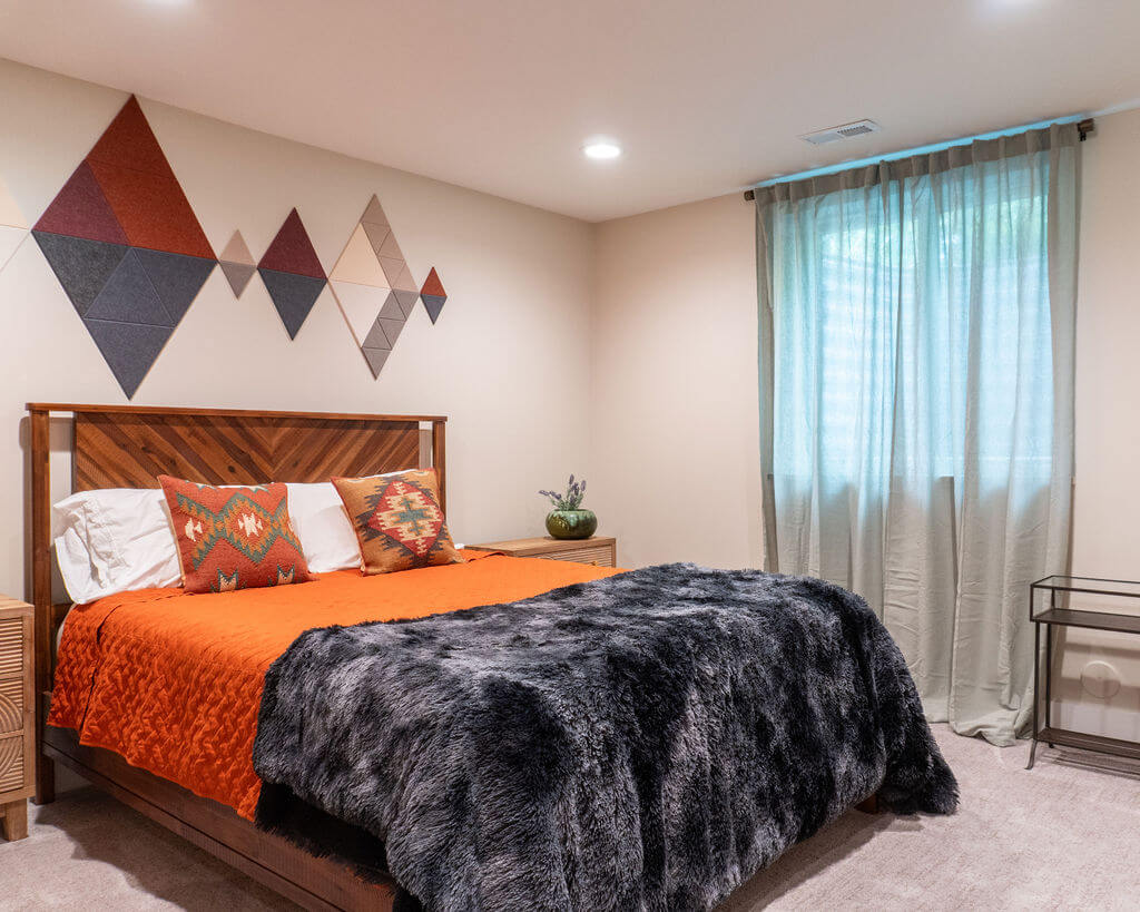 Guest bedroom in the basement with curtains hung in front of the window and a bed positioned between two nightstands.