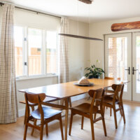 Thumbnail of http://Dining%20room%20with%20natural%20light%20from%20the%20window%20and%20door%20to%20the%20deck,%20a%20modern%20light%20fixture,%20and%20wood%20table%20with%20seating%20for%20six.
