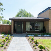 Thumbnail of http://Mid-century%20house%20exterior%20with%20a%20walk-way%20to%20the%20front%20door,%20front%20porch,%20and%20modern%20landscaping.