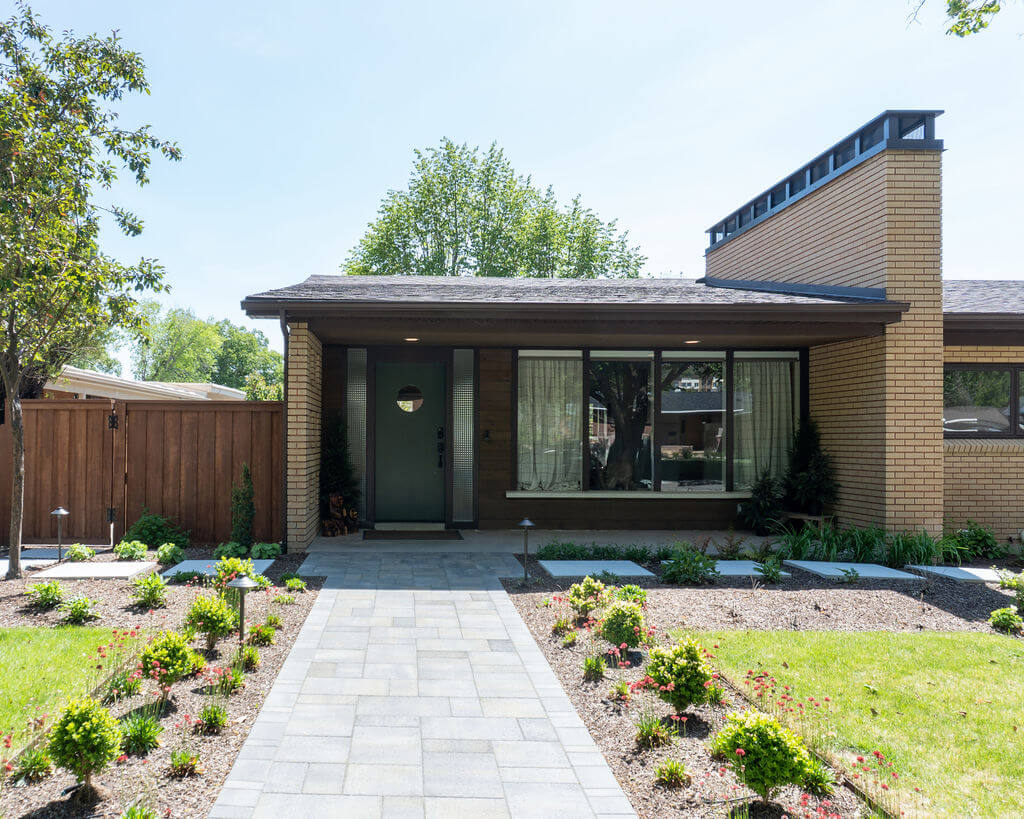 Mid-century house exterior with a walk-way to the front door, front porch, and modern landscaping.