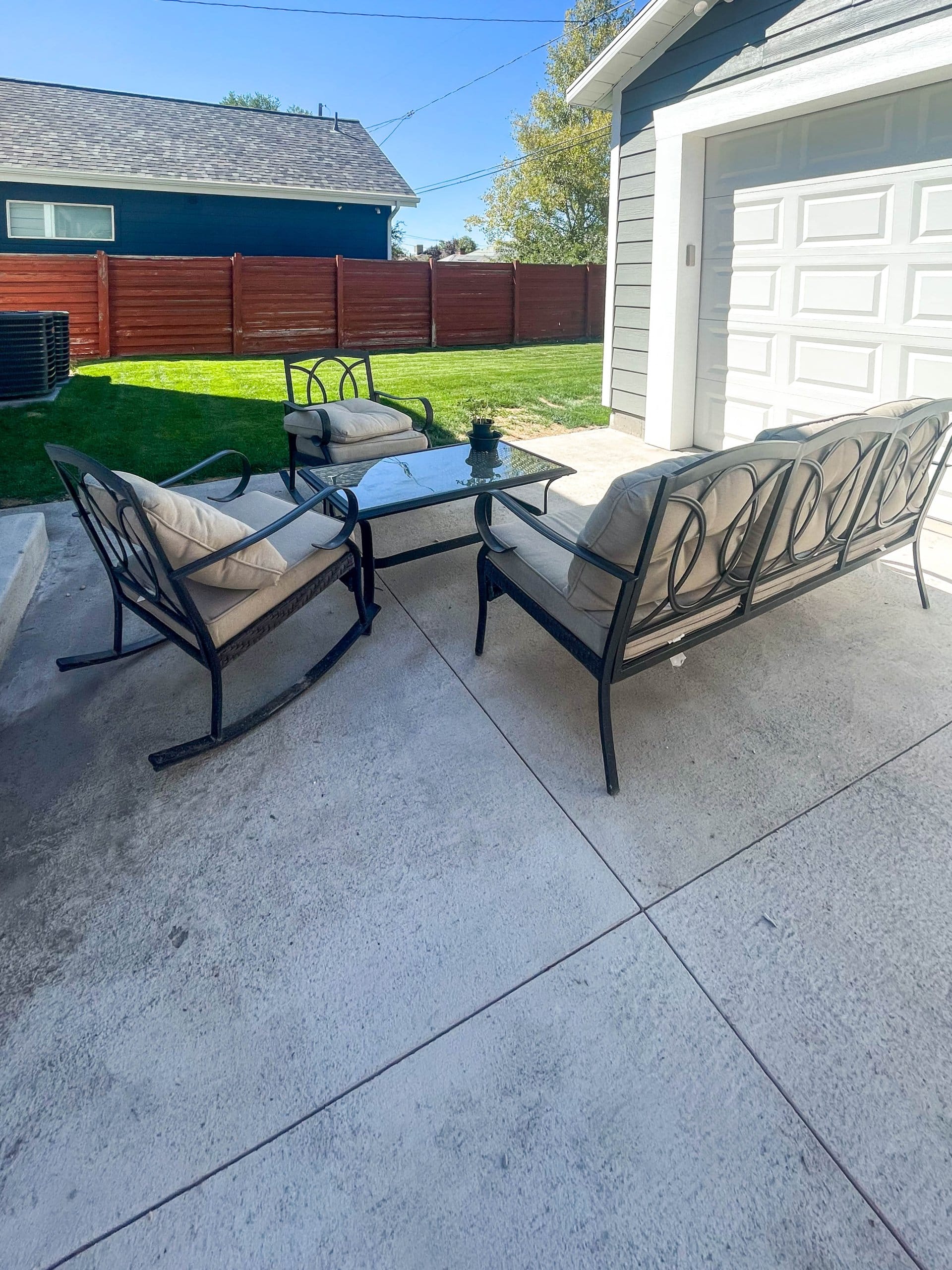 Garage with patio furniture on the driveway.