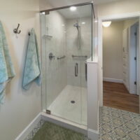 Thumbnail of http://Shower%20with%20glass%20door.%20In%20front%20of%20the%20shower%20door%20is%20a%20green%20bath%20mat%20placed%20on%20top%20of%20the%20tile.%20Two%20towels%20are%20hung%20on%20the%20wall%20hooks%20to%20the%20side%20of%20the%20shower.%20The%20door%20to%20the%20bathroom%20is%20open%20and%20looks%20into%20the%20hallway.