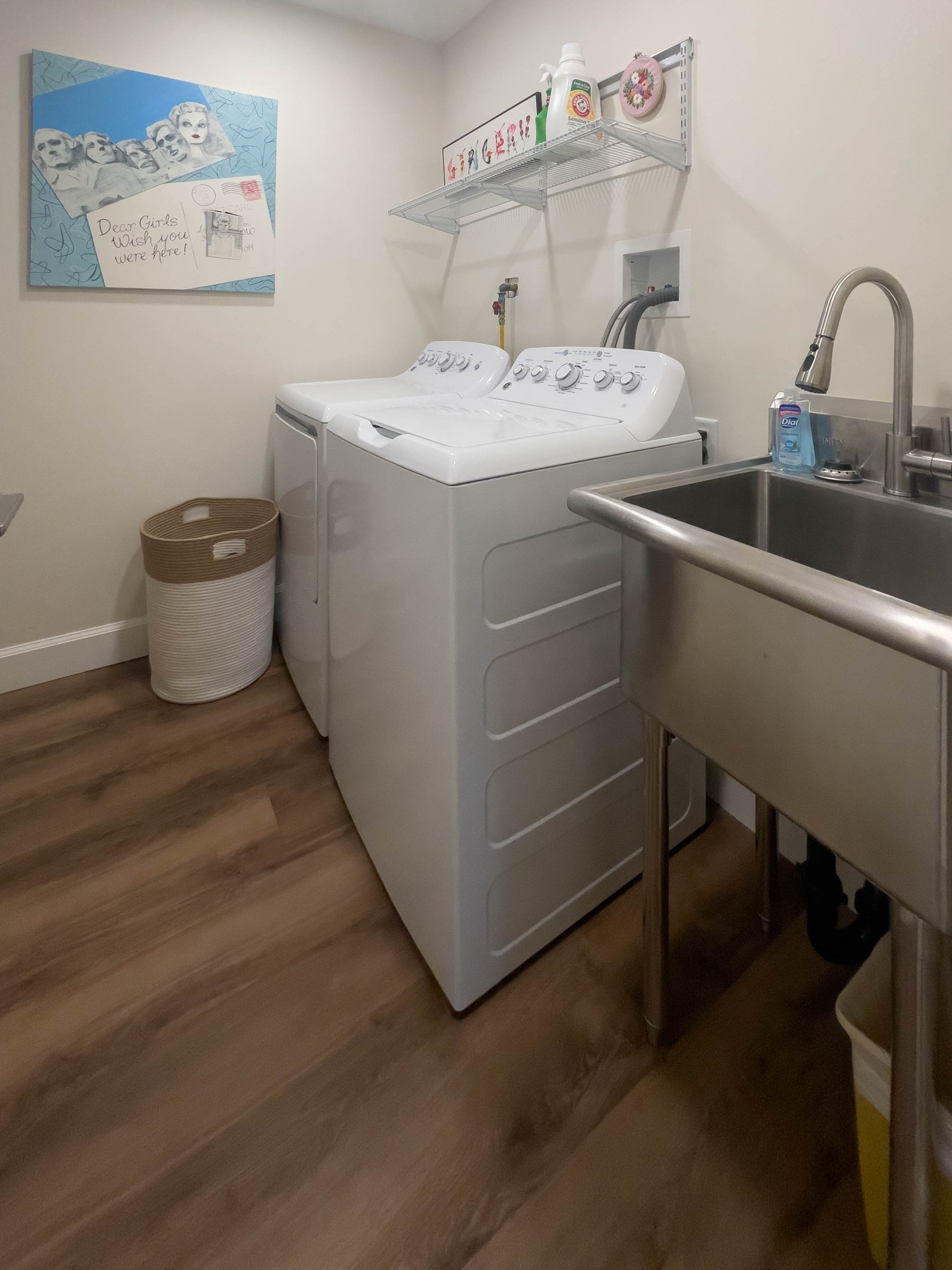 Laundry room with side-by-side washer and dryer, a shelf above, and a sink to the side.