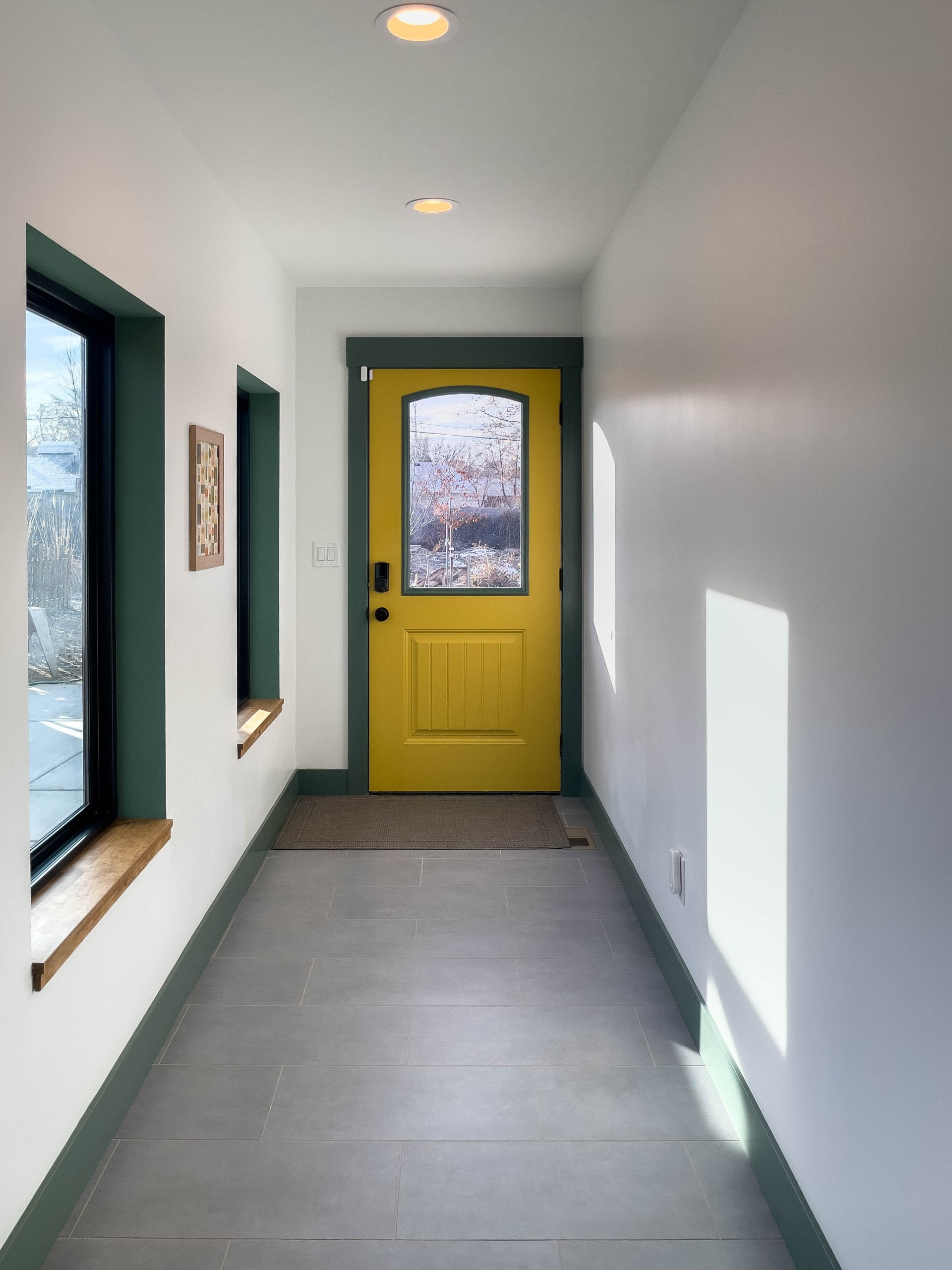 Hallway with tile on the floor leading to an exterior door.