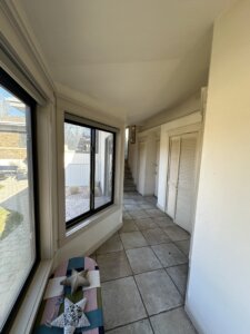 Mudroom before the remodel featuring tile flooring, windows, and closets.
