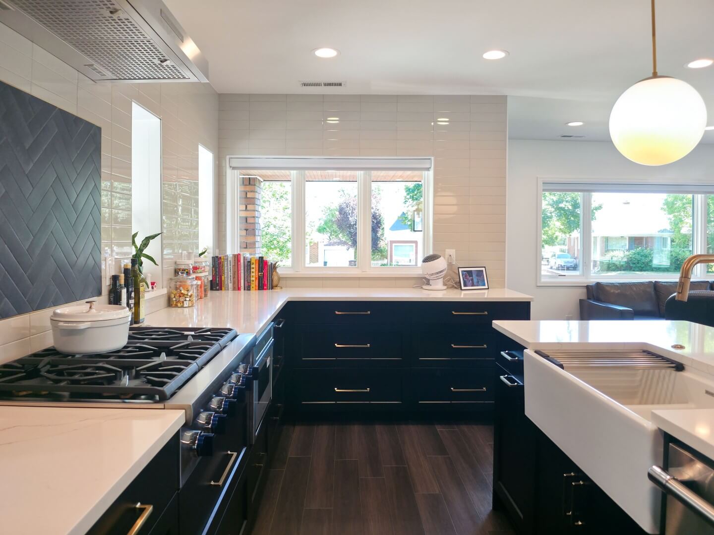 Open concept kitchen with the counter and cabinets around, a stove to the left, and a sink in the island to the right.