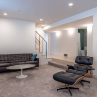 Thumbnail of http://Sunken%20family%20room%20in%20the%20basement%20that%20is%20furnished%20with%20a%20couch,%20coffee%20table,%20and%20chair.