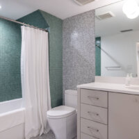 Thumbnail of http://Modern%20bathroom%20with%20a%20large%20vanity,%20toilet,%20and%20shower%20and%20tub%20combination.