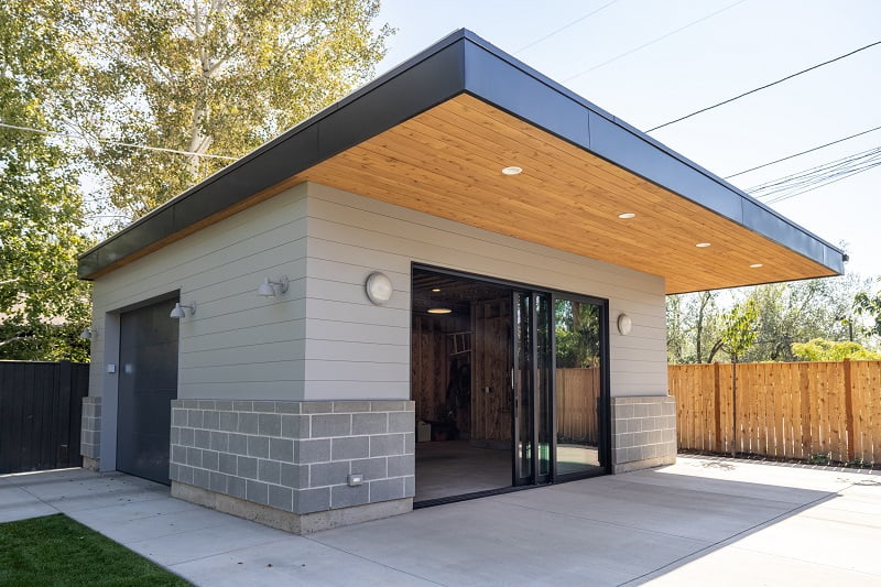 Modern garage building that doubles as entertaining space with a sliding door that opens to the covered patio.