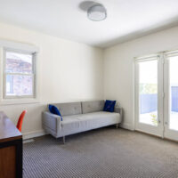 Thumbnail of http://Home%20office%20with%20a%20door%20to%20the%20backyard,%20couch,%20and%20desk.