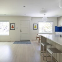 Thumbnail of http://Open%20concept%20kitchen,%20dining%20room,%20and%20living%20room.%20The%20kitchen%20includes%20a%20large%20island%20and%20blue%20tile%20backsplash.