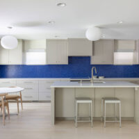 Thumbnail of http://Modern%20kitchen%20renovation%20that%20is%20open%20to%20the%20dining%20room%20and%20has%20an%20island,%20blue%20tile%20backsplash,%20and%20lots%20of%20natural%20light.