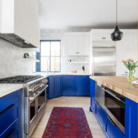 Thumbnail of http://Large%20modern%20kitchen%20with%20blue%20lower%20cabinets%20and%20white%20upper%20cabinets.%20The%20sink%20is%20located%20at%20an%20angle%20in%20the%20corner%20with%20windows%20above.