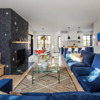 Thumbnail of http://Open%20concept%20living%20room%20with%20a%20view%20to%20the%20dining%20room%20and%20kitchen.%20In%20the%20living%20room%20is%20a%20large%20blue%20couch,%20two%20chairs,%20and%20a%20fireplace.
