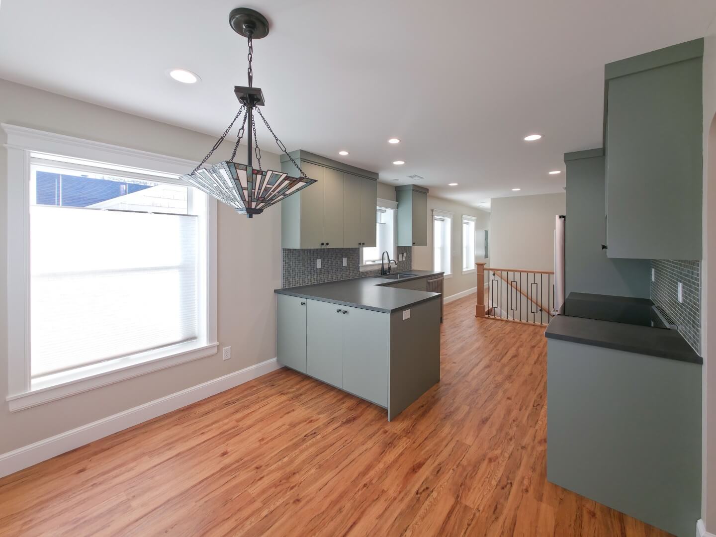 Renovated kitchen that is open to the dining room and includes a peninsula, updated appliances, and wood flooring.