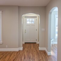Thumbnail of http://Small%20entry%20looking%20through%20an%20archway%20to%20the%20front%20door.