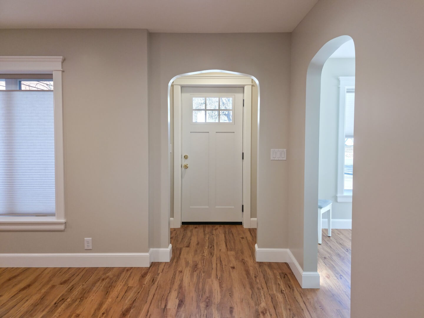 Small entry looking through an archway to the front door.