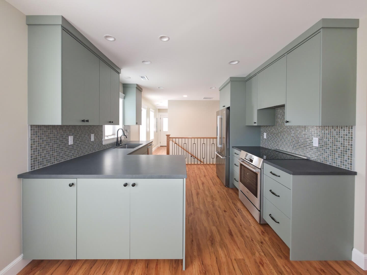 Renovated kitchen that is open to the dining room and includes a peninsula, updated appliances, and wood flooring.