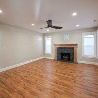 Thumbnail of http://Renovated%20living%20room%20with%20a%20ceiling%20fan,%20updated%20fireplace,%20wood%20flooring,%20and%20multiple%20windows.