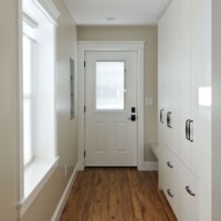 Thumbnail of http://Newly%20created%20mudroom%20with%20cabinetry%20and%20a%20built-in%20bench%20on%20the%20right,%20a%20brand%20new%20door%20with%20access%20to%20the%20backyard%20straight%20ahead,%20and%20a%20window%20on%20the%20left.