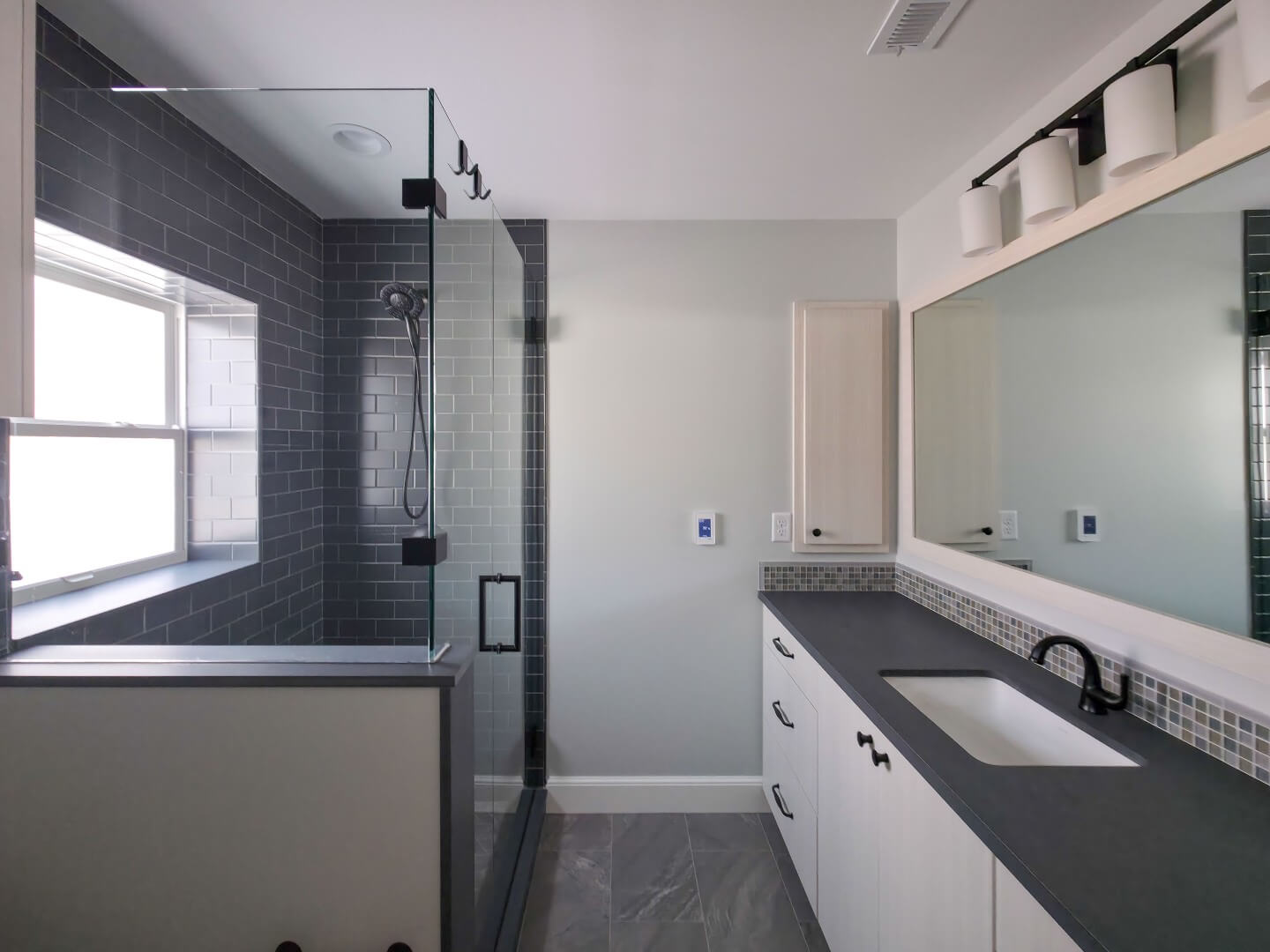 New primary suite bathroom with a large vanity on the right and a shower on the left.