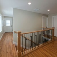 Thumbnail of http://Renovated%20staircase%20with%20a%20new%20railing.%20On%20the%20left%20is%20the%20mudroom%20with%20a%20door%20to%20the%20backyard,%20and%20on%20the%20right%20are%20two%20doors%20with%20one%20leading%20to%20the%20powder%20bathroom%20and%20the%20other%20to%20the%20primary%20suite.