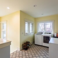 Thumbnail of http://Laundry%20room,%20mudroom%20with%20Craftsman%20style%20windows,%20geometric%20tile,%20yellow%20walls,%20and%20a%20washer%20and%20dryer