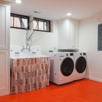 Thumbnail of http://Renovated%20laundry%20room%20with%20a%20large%20sink%20and%20side-by-side%20washer%20and%20dryer.