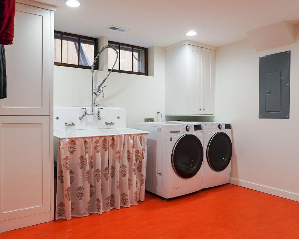 Renovated laundry room with a large sink and side-by-side washer and dryer.