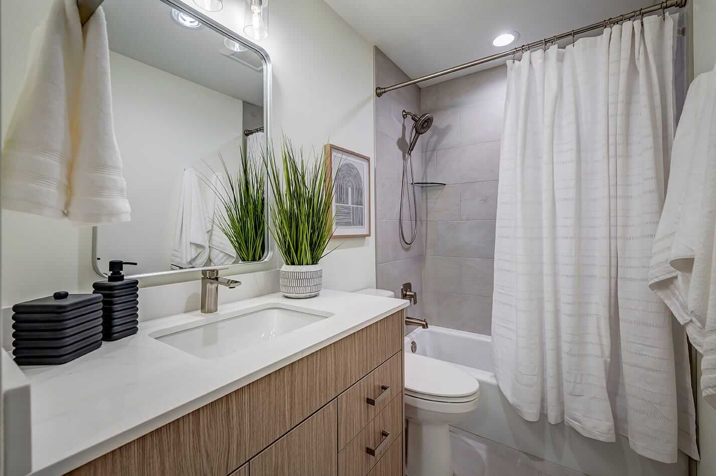 Updated bathroom with a sink, toilet, and shower and tub combination.