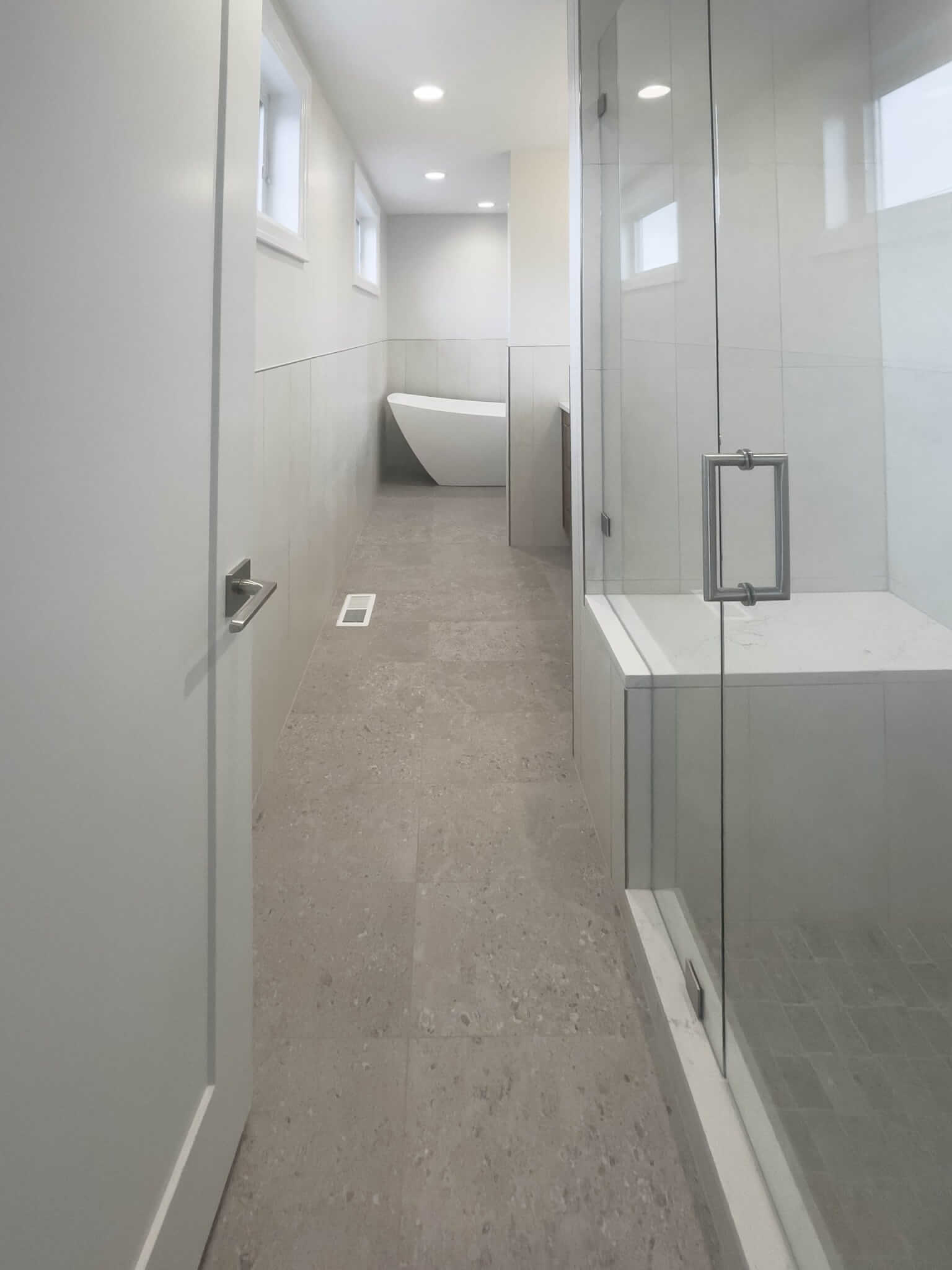 Large primary bathroom looking past the shower toward the tub.