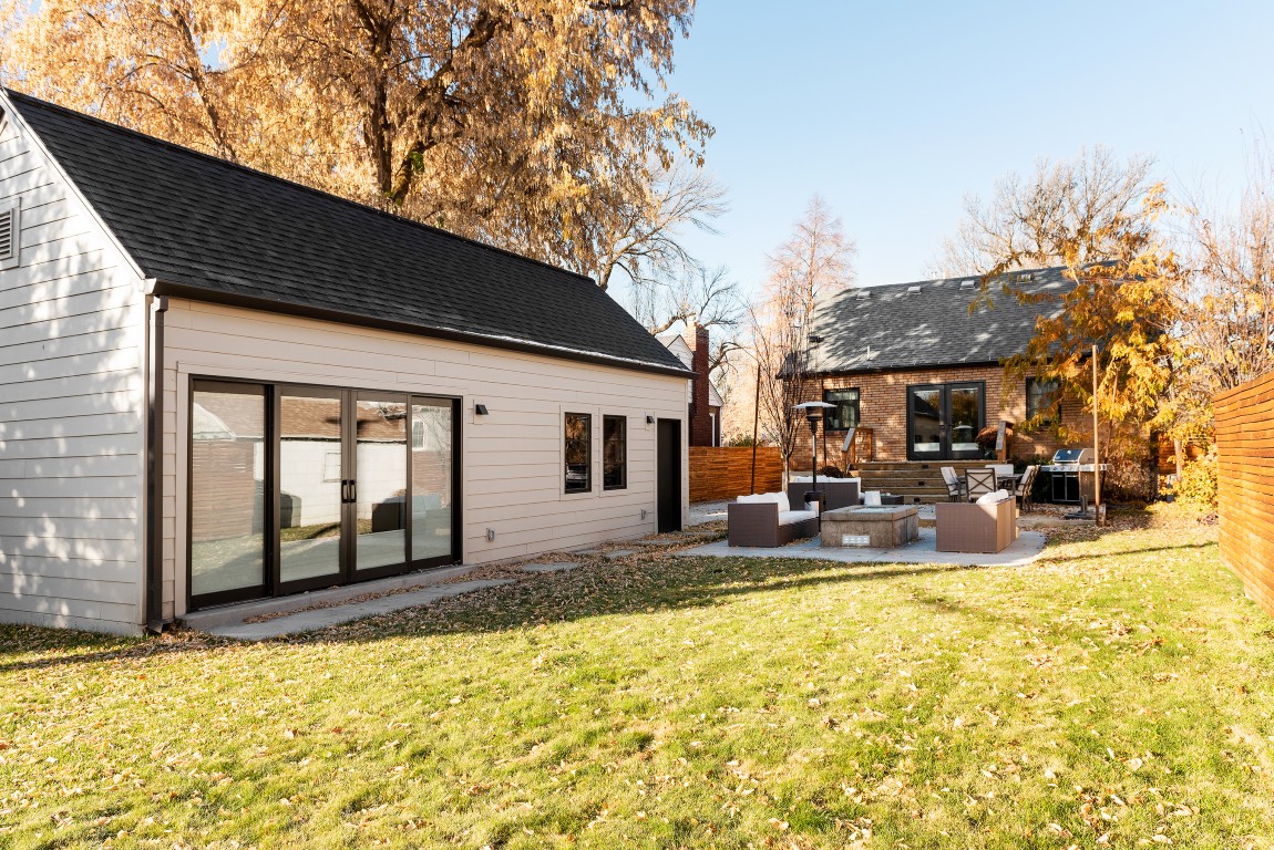 Large backyard with a one-car garage and studio space to the left, and the house and patio straight ahead.