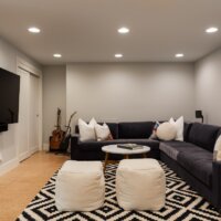 Thumbnail of http://Basement%20family%20room%20with%20a%20large%20l-shaped%20couch,%20coffee%20table,%20ottomans,%20and%20TV.%20On%20the%20left,%20is%20a%20sliding%20closet%20door.