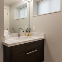 Thumbnail of http://Modern%20bathroom%20vanity%20design.%20The%20sink%20is%20centered%20on%20the%20counter,%20includes%20a%20drawer%20below,%20and%20a%20mirror%20and%20light%20on%20the%20wall%20above.%20On%20the%20wall%20to%20the%20right,%20is%20a%20small%20window.