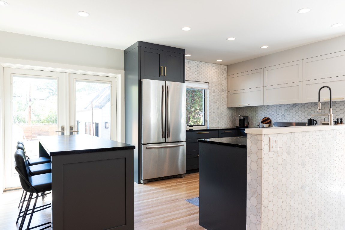 Open concept kitchen and dining room. The dining room includes two large doors with access to the backyard.
