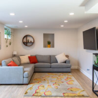 Thumbnail of http://Basement%20family%20room%20with%20an%20L-shaped%20couch,%20TV%20mounted%20on%20the%20wall,%20and%20a%20fish%20tank.