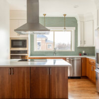 Thumbnail of http://Renovated%20kitchen.%20The%20space%20includes%20a%20sink%20with%20white%20and%20gold%20light%20fixtures%20and%20a%20window%20above,%20fridge,%20and%20stove%20in%20the%20island.