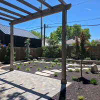 Thumbnail of http://Freshly%20landscaped%20backyard.%20The%20yard%20includes%20a%20patio%20with%20a%20pergola,%20stone%20pathways,%20retaining%20wall,%20and%20various%20plants.
