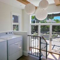 Thumbnail of http://The%20laundry%20room%20section%20of%20the%20addition%20is%20located%20between%20the%20kitchen%20and%20mudroom.%20The%20space%20features%20lots%20of%20natural%20light,%20wood%20beams%20on%20the%20ceiling,%20and%20three%20round%20light%20fixtures.