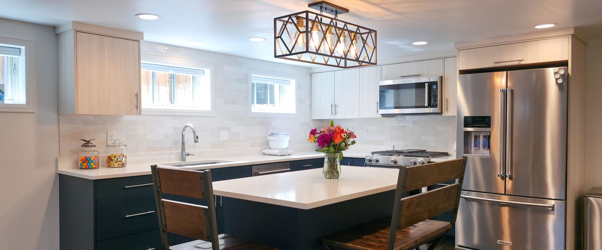 Basement apartment kitchen with an island, multiple windows, and lots of storage.
