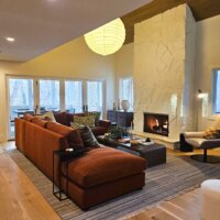 Thumbnail of http://Living%20room%20with%20large%20couch,%20fireplace,%20and%20natural%20light%20from%20the%20windows.