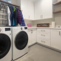 Thumbnail of http://Laundry%20room%20with%20side-by-side%20washer%20and%20dryer,%20cabinetry,%20hanging%20rod,%20and%20a%20sink.