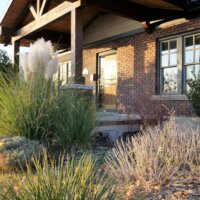 Thumbnail of http://Front%20exterior%20renovation%20at%20a%20brick%20house%20featuring%20a%20covered%20front%20porch%20and%20new%20landscaping.