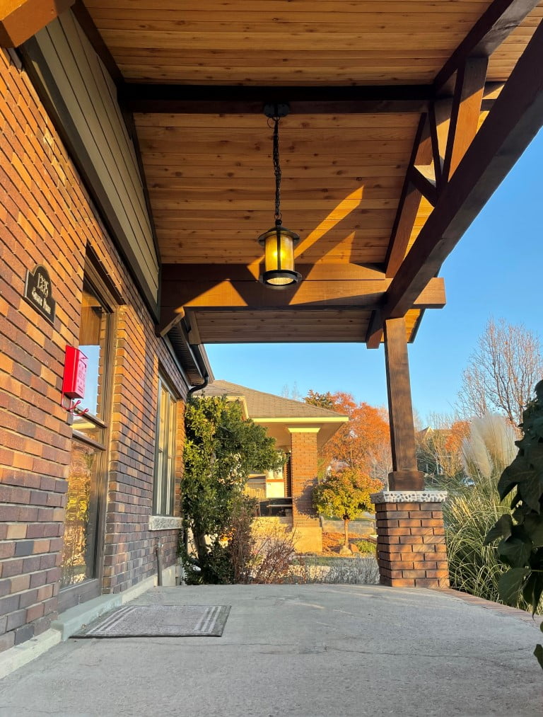 Covered front porch with a vaulted ceiling and light hung from above.